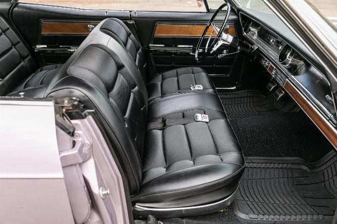 Переднее сиденье четырехдверного хардтопа Chevrolet Caprice Evening Orchid 1965 года с черной тканевой отделкой, вид через переднюю пассажирскую дверь