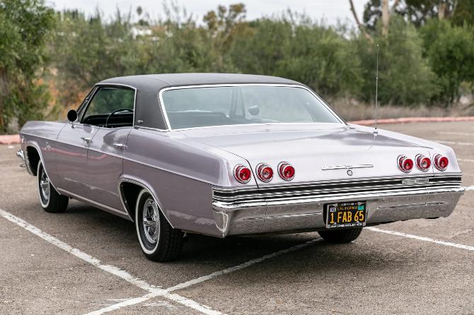 Вид сзади, 3 кв. сантиметра, на четырехдверный хардтоп Chevrolet Caprice Evening Orchid 1965 года с черным виниловым верхом и черным номерным знаком California