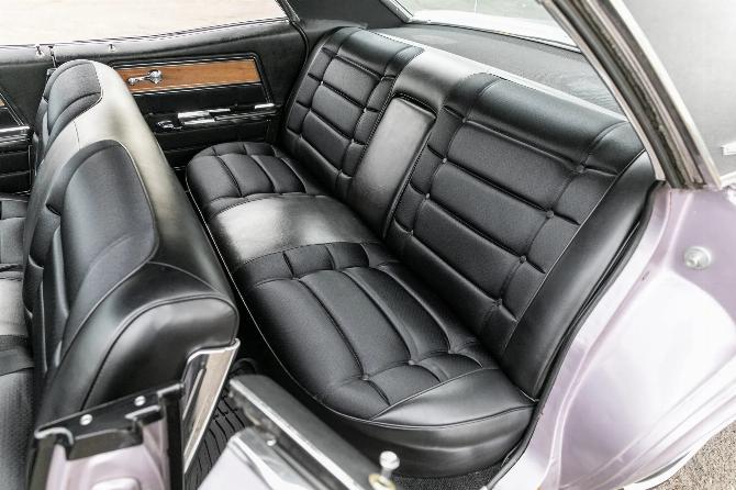 Заднее сиденье четырехдверного хардтопа Chevrolet Caprice Evening Orchid 1965 года с черной тканевой отделкой, вид через левую заднюю дверь